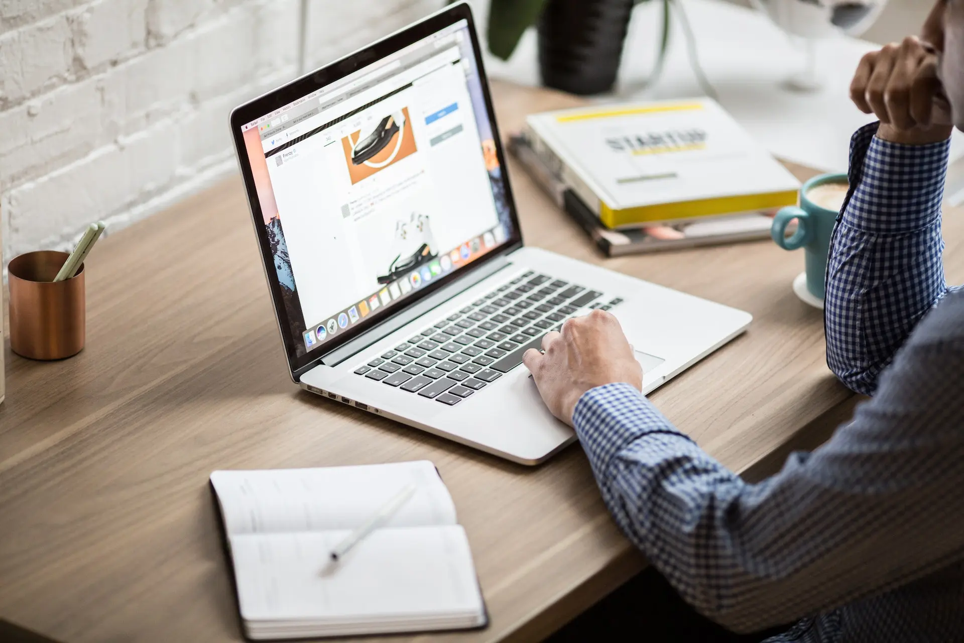 Person working on laptop at wooden desk