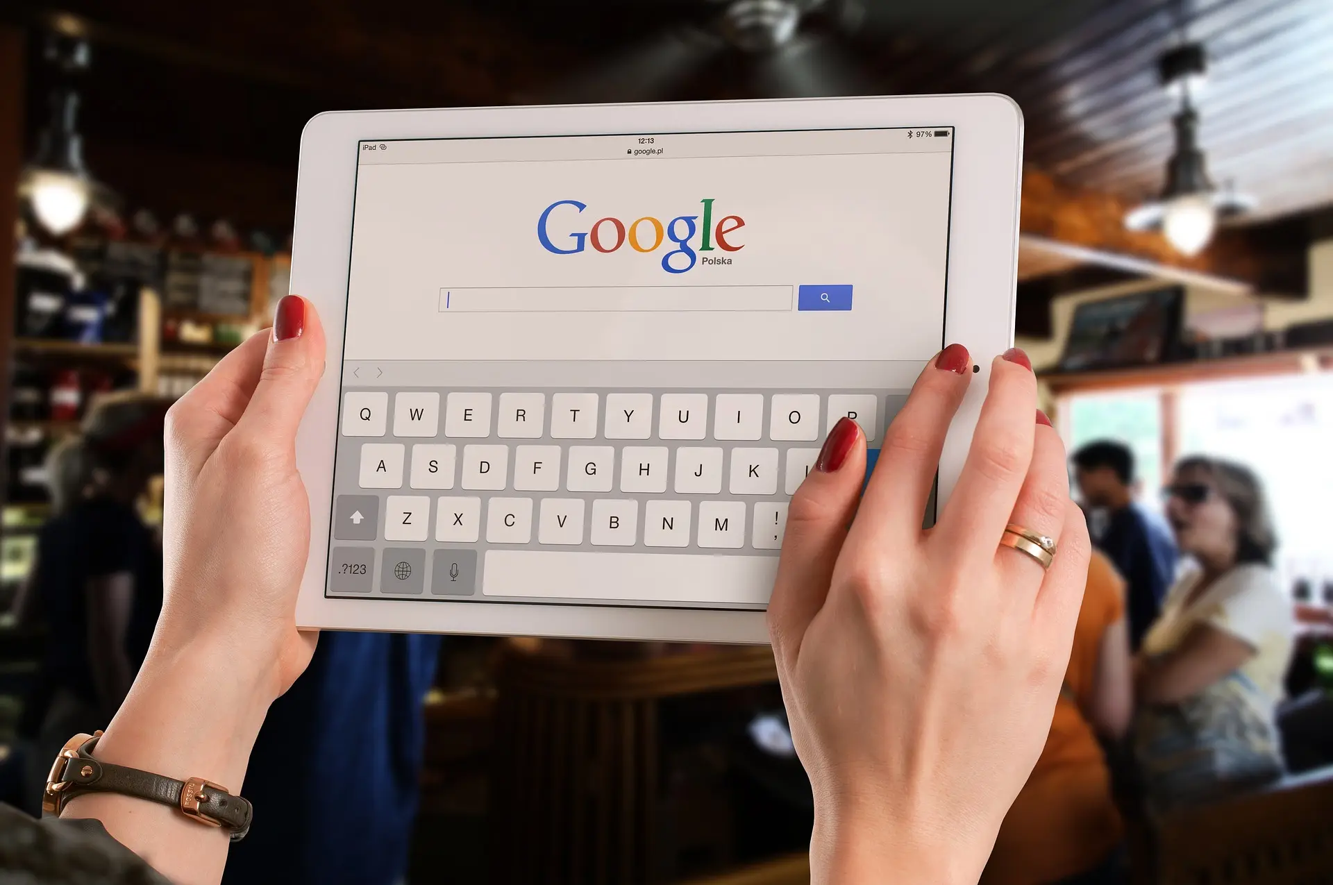 Person using Google search on tablet in cafe
