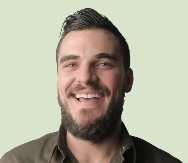 Smiling man with beard against light background